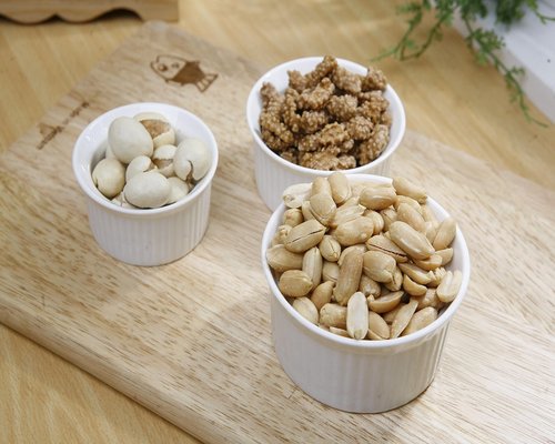 A variety of healthy nuts and seeds in small ceramic bowls