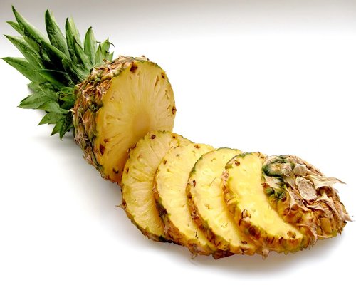 Slices of fresh tropical pineapple and sweet papaya served on a platter