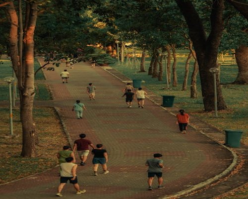 People walking in an urban public green park in the evening representing active lifestyle