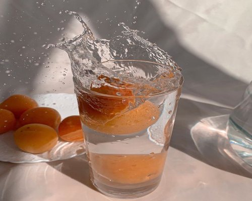 A clean glass of pure water next to local Thai fruits suggesting hydration in summer